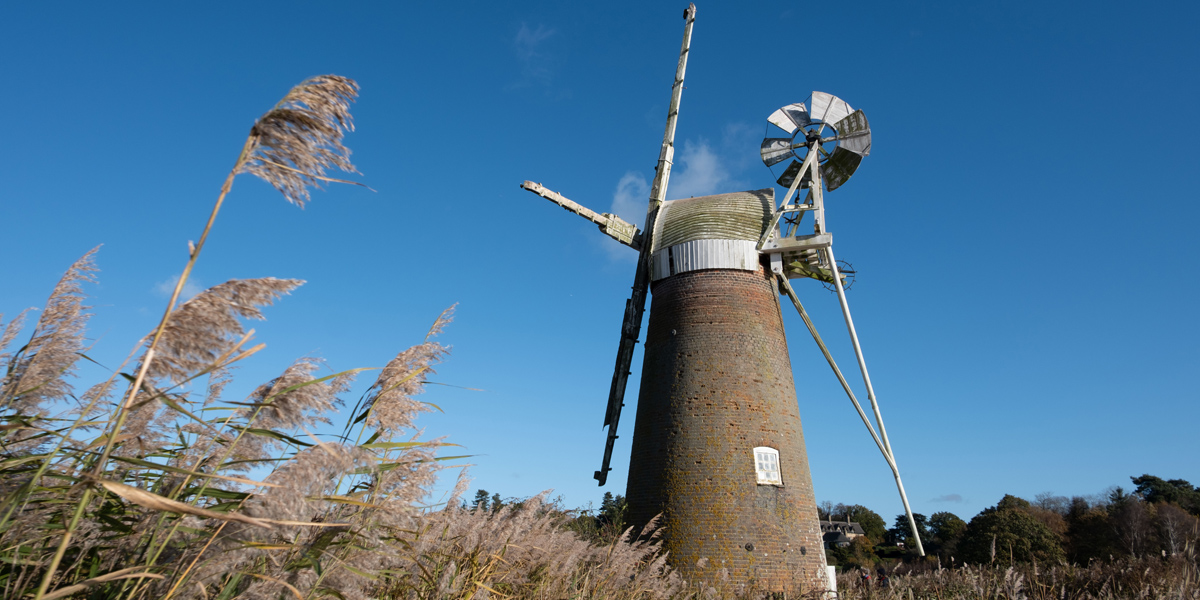 Red-bricked Turf Fen Mill against the backdrop of a blue sky