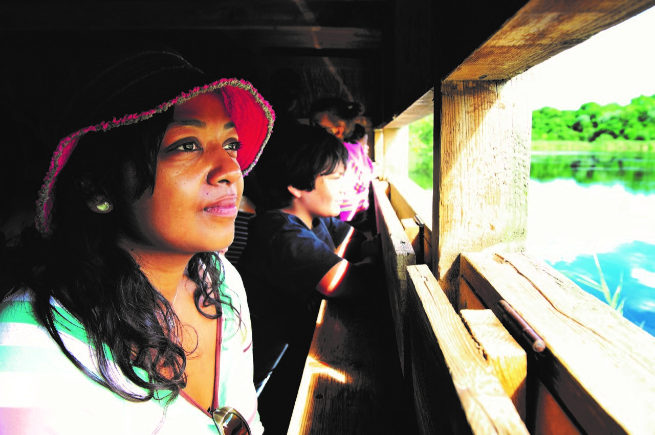 woman looking out of bird hide in the broads