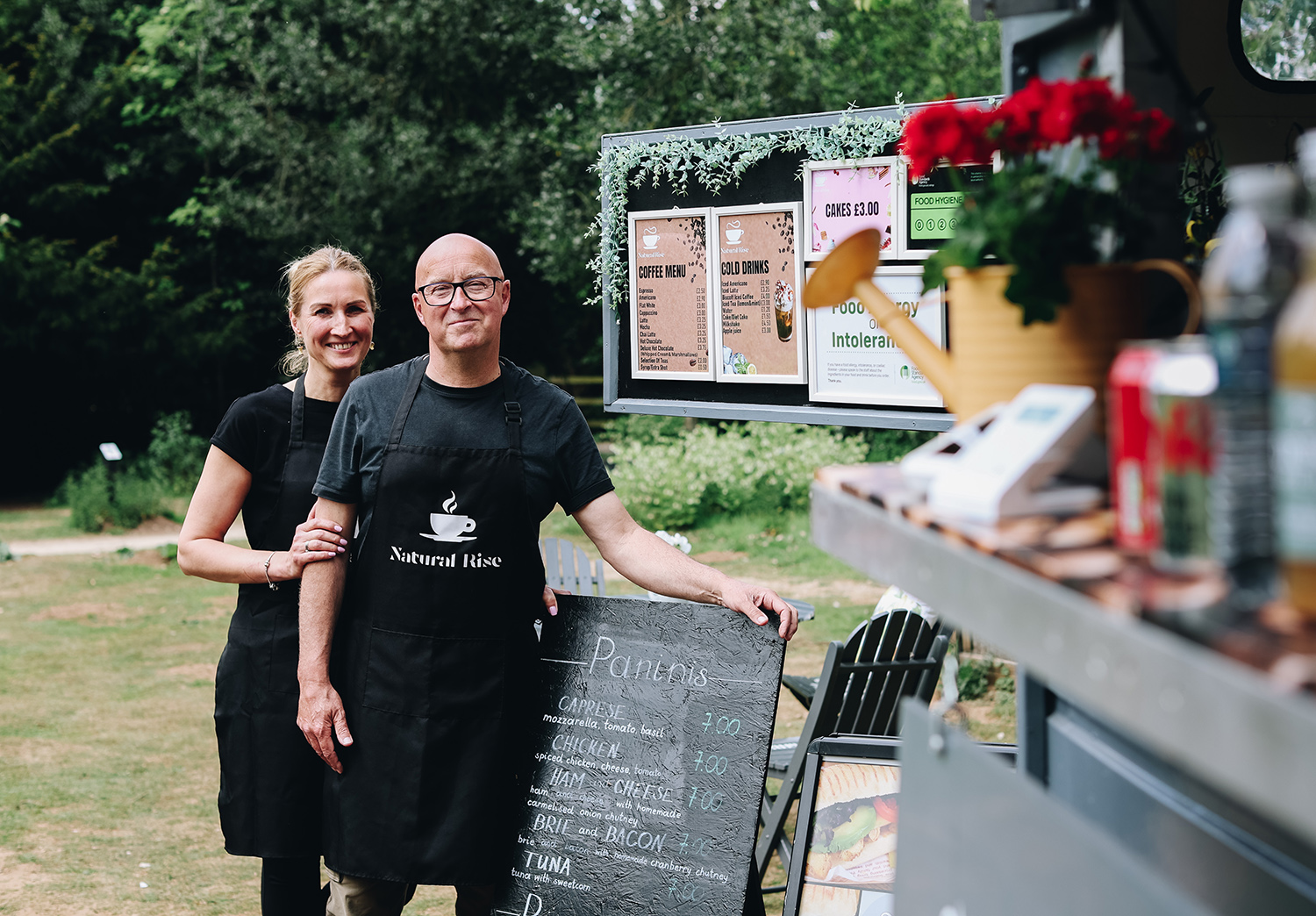 The Natural Rise team at How Hill Two Natural Rise team members standing beside their outdoor food trailer at How Hill.