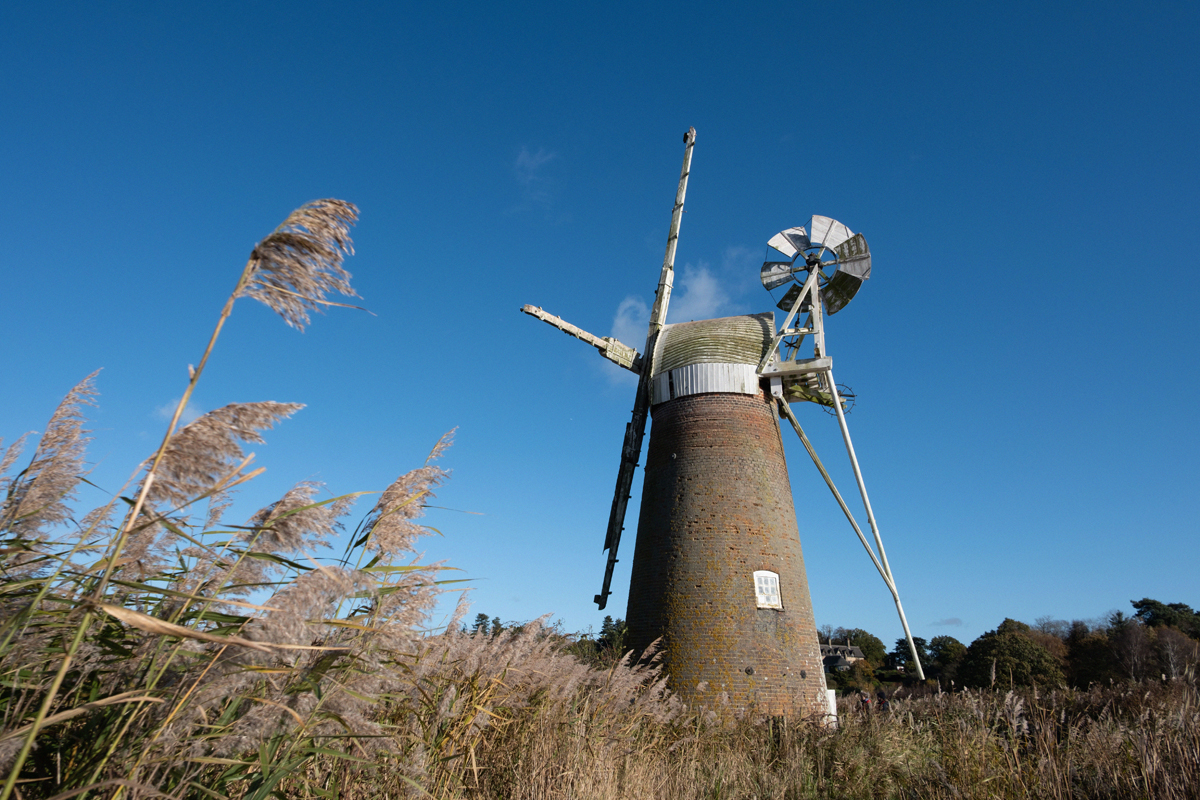 Red-bricked Turf Fen Mill against the backdrop of a blue sky
