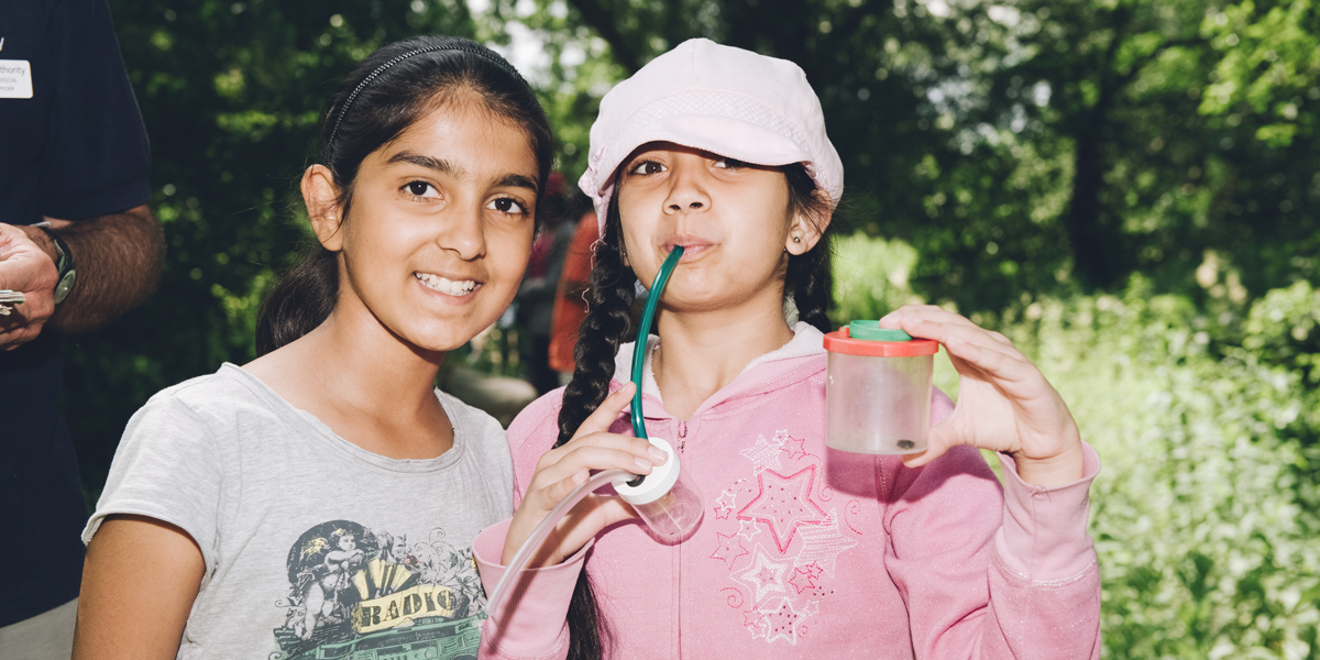 Two schoolchildren posing with bug collecting equipment