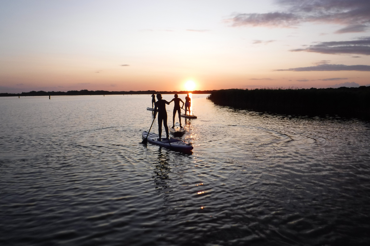 paddleboarding at sunset