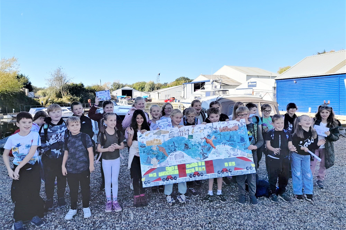 Group of children posing with a large piece of artwork they have created