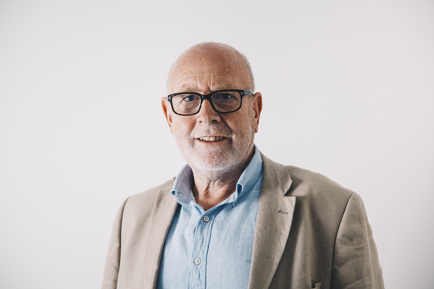 Harry Blathwayt, Broads Authority Chair A photo of Harry Blathwayt with glasses on, wearing a light blue shirt and beige blazer, smiling in front of a plain white background.
